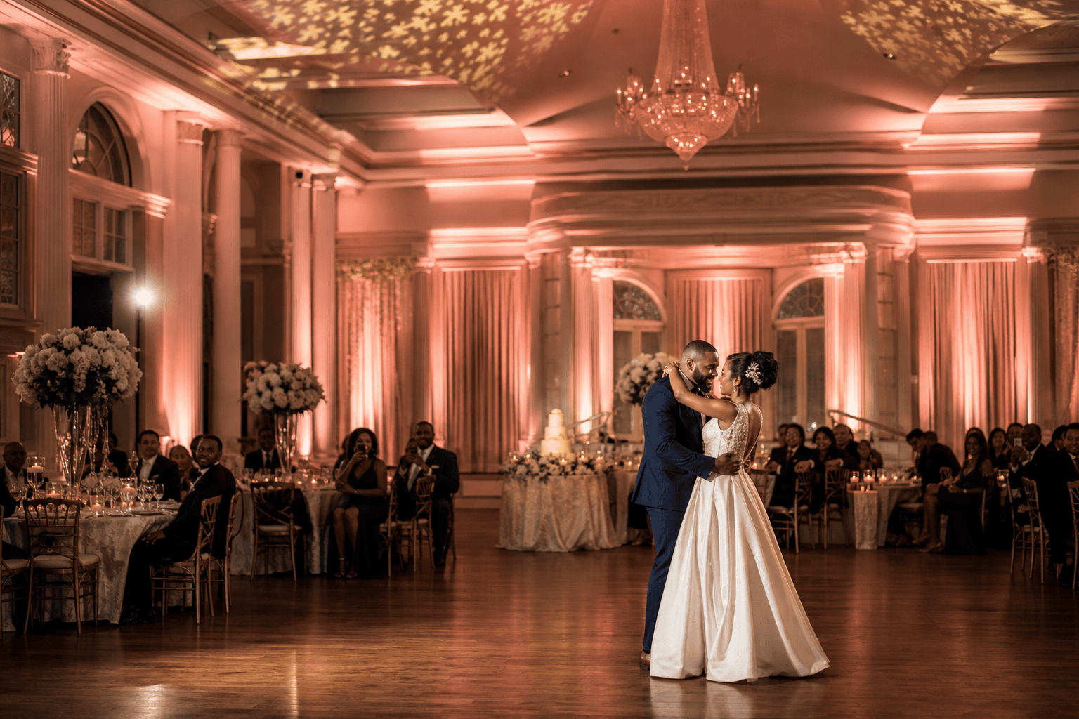 Bride and groom dancing under warm amber uplighting at an elegant wedding reception in Fayetteville, NC.